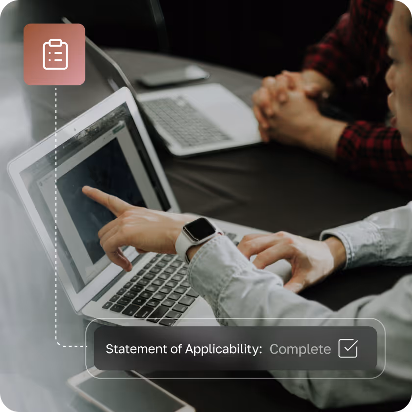 Person pointing at a laptop screen with an overlay showing 'Statement of Applicability: Complete' and a checkbox.