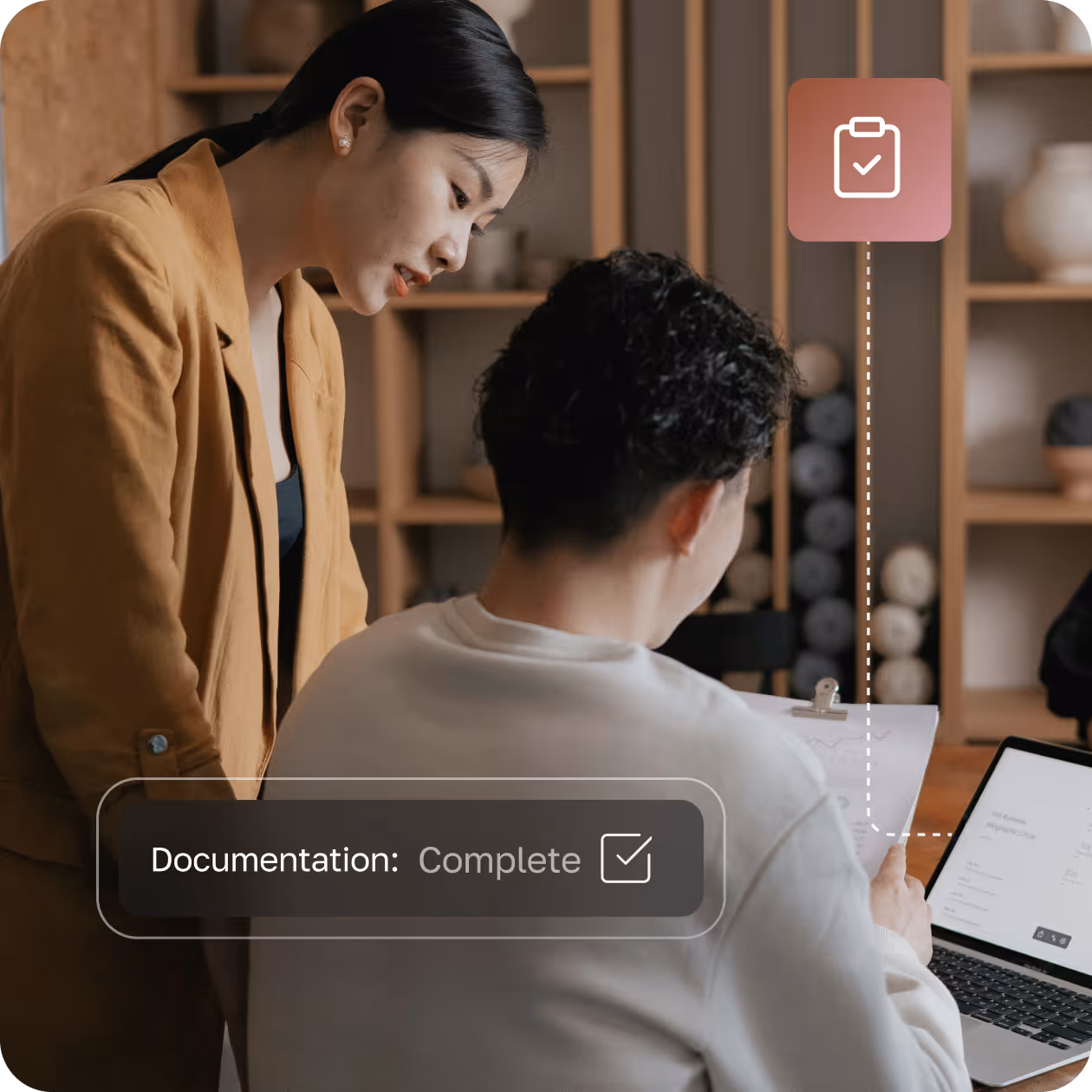 Two people reviewing documents together, with a laptop and a completed documentation checklist icon overlay.