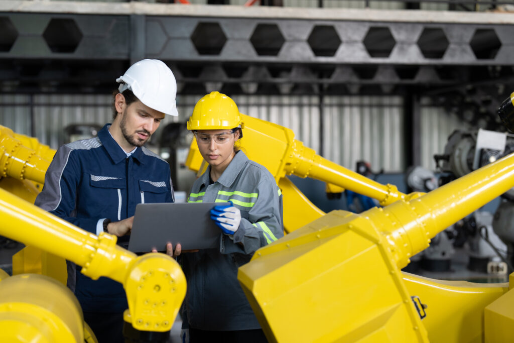 Engineers quality checking robot arm welding machine