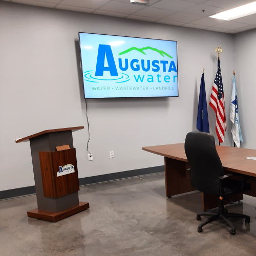 picture of board meeting room at field ops with podium and tv with logo