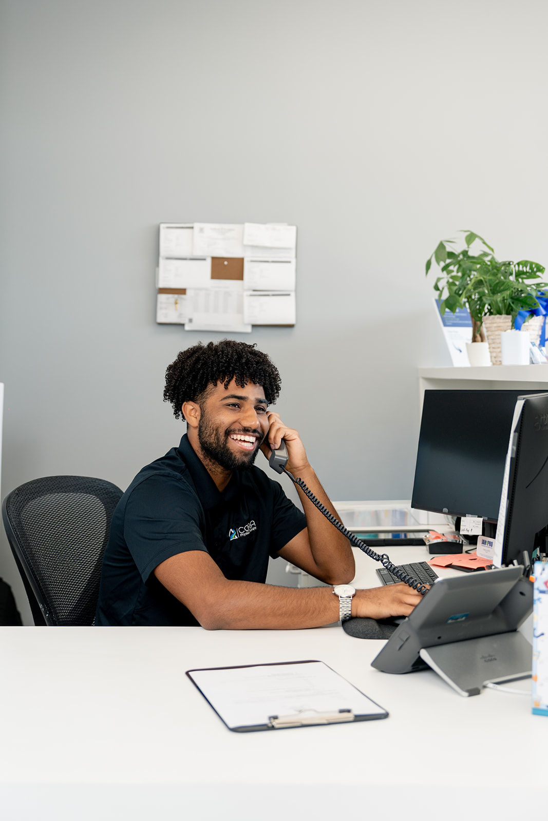a cora physical therapy employee taking a phone call