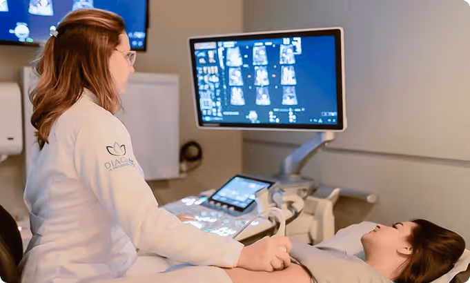 Profissional de saúde realiza exame de ultrassom em paciente deitada em clínica médica.