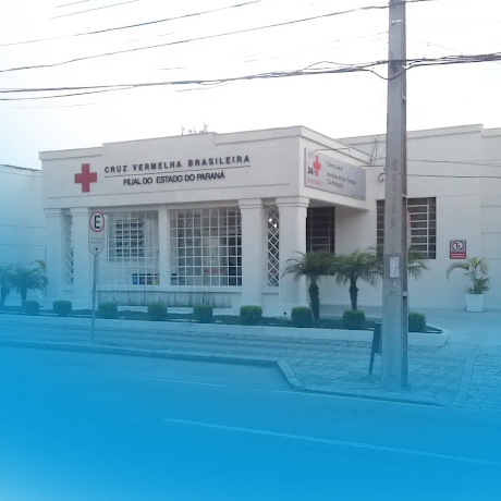 Fachada da Cruz Vermelha Brasileira, filial do estado do Paraná, com plantas e calçada externa.