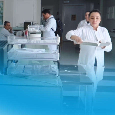 Profissionais de saúde em jalecos brancos organizando documentos em um ambiente hospitalar.