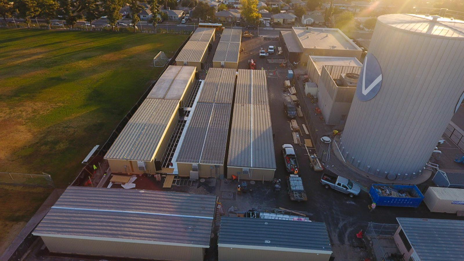 Aerial view of modular buildings and work trucks at a job site