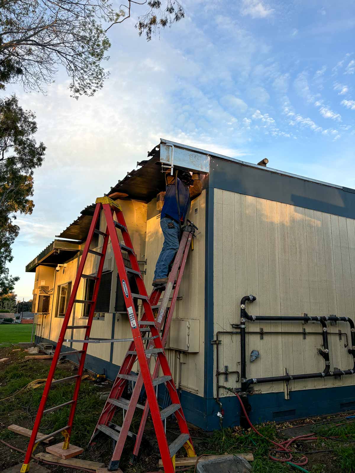Before: exposed and damaged roof edge with crew ladder in place