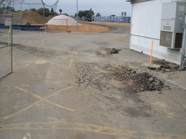 Site excavation and gravel stockpile beside the existing school building