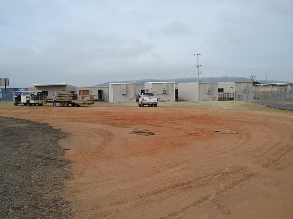 Cleared site with modular units staged in the background