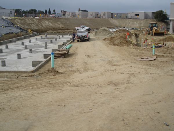 Concrete footings and graded pad prepared at the school site
