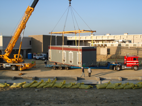 Crane lifting a modular restroom unit into place at Dana Point High School