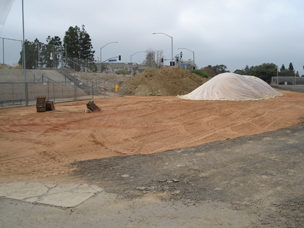 Graded dirt pad and gravel stockpile ready for construction