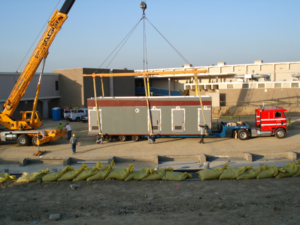 Crane lifting a modular module over the prepared foundation