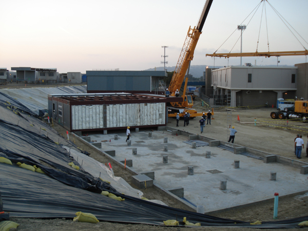 Crane lowering a modular module onto the prepared foundation