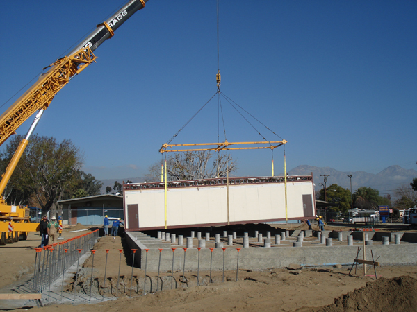 Crane setting a custom modular building onto its foundation in Hesperia