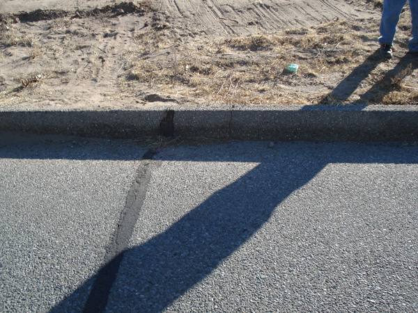 Finished concrete curb and gravel along the site edge