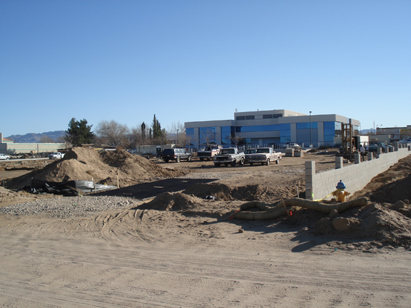 Graded site and stockpiled soil beside the adjacent building