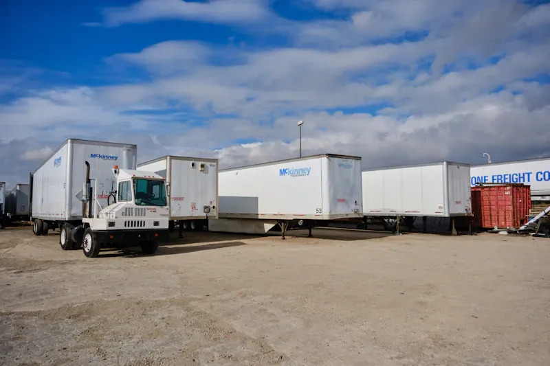 Fleet service for heavy-duty trucks and trailers, showing McKinney semi-trailers and a yard truck parked at a freight facility.
