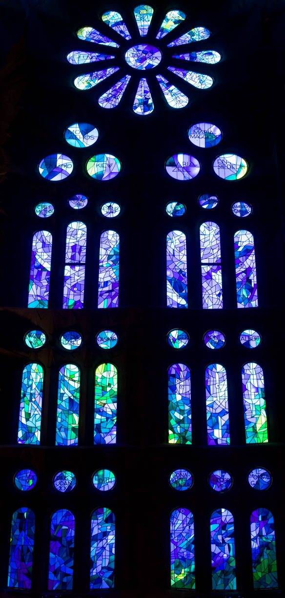A stained glass window inside the famous Sagrada Família cathedral in Barcelona, Spain. This stain glass window is entirely blue with some green.