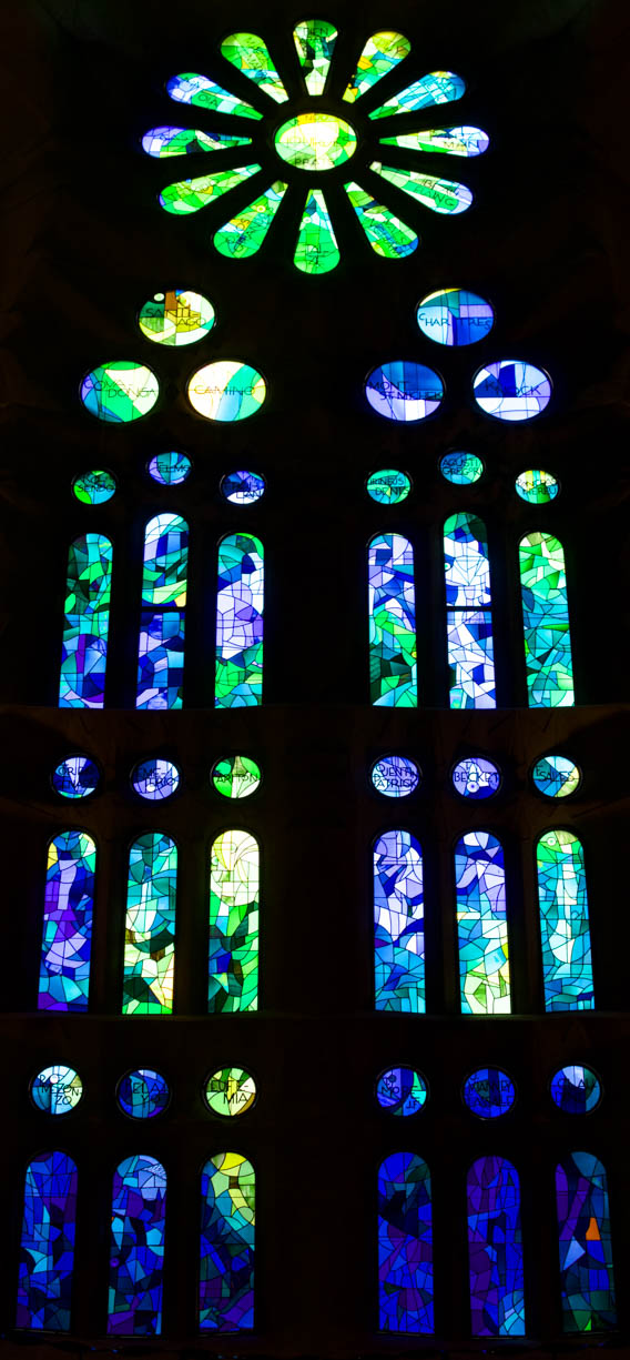 A stained glass window inside the famous Sagrada Família cathedral in Barcelona, Spain. This stain glass window is half green and half blue.