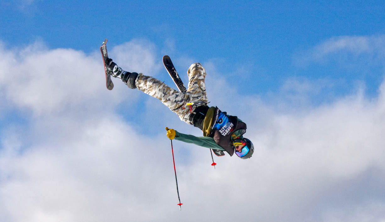 A flying free skier at the 2019 Alberta Freeski competition at the Lake Louise Ski Resort in Banff, Alberta, Canada. The skier is upside down soaring through the air.