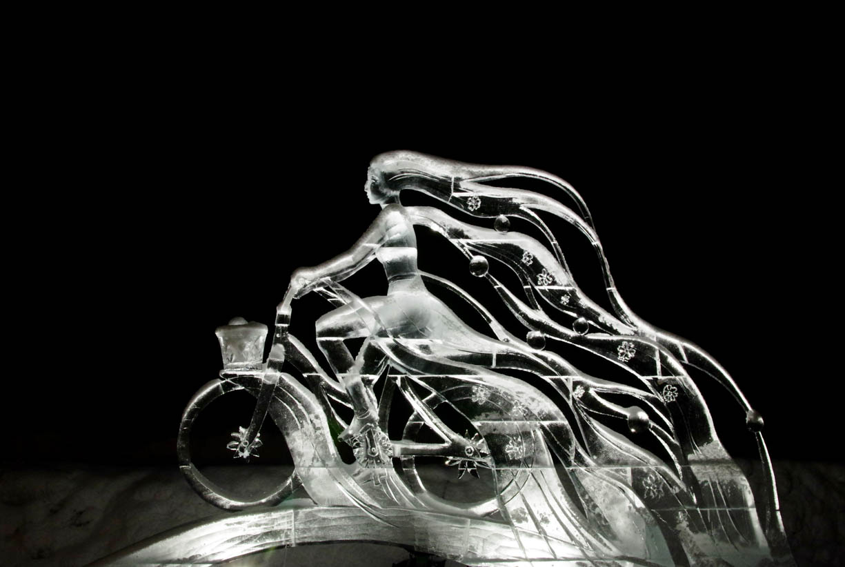 An ice sculpture of a woman cyclist with extremely long flowing hair from the Lake Louise Ice Carving Festival during the winter of 2019-2020.