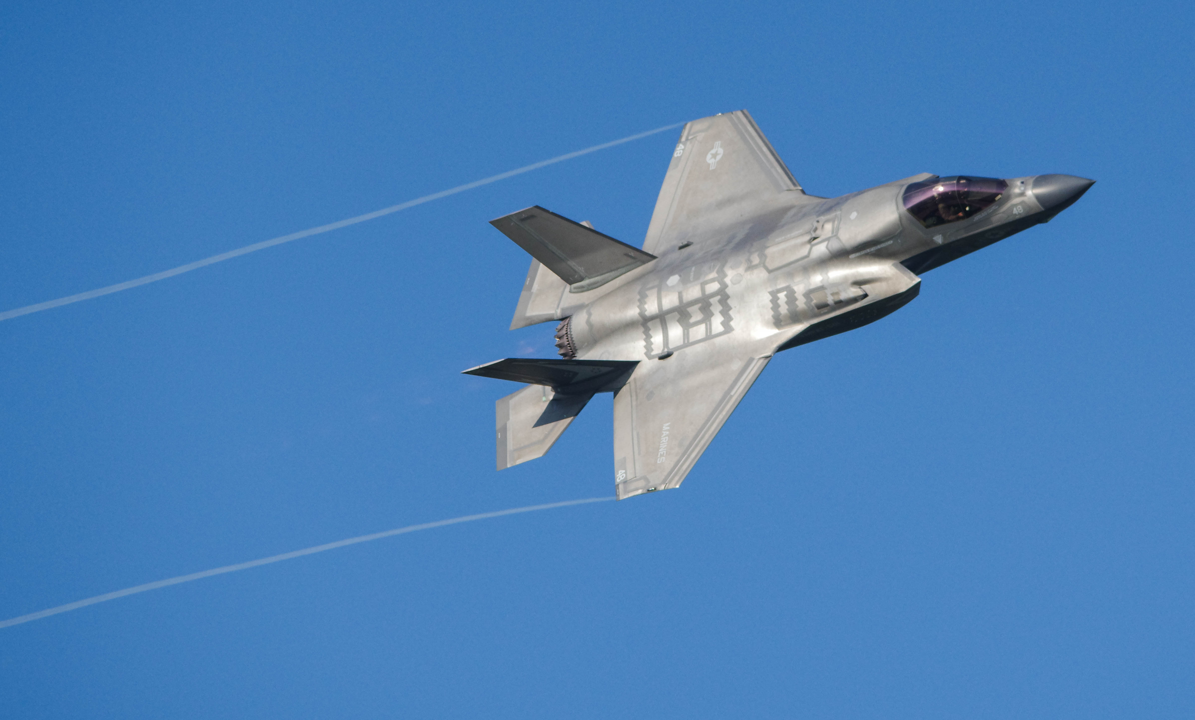 A red and blue stock car racing at high speeds at the Paragon Speedway in Bloomington, Indiana. The racecar is racing at high speeds in the night time, therefore, it is illuminated by the bright lights
