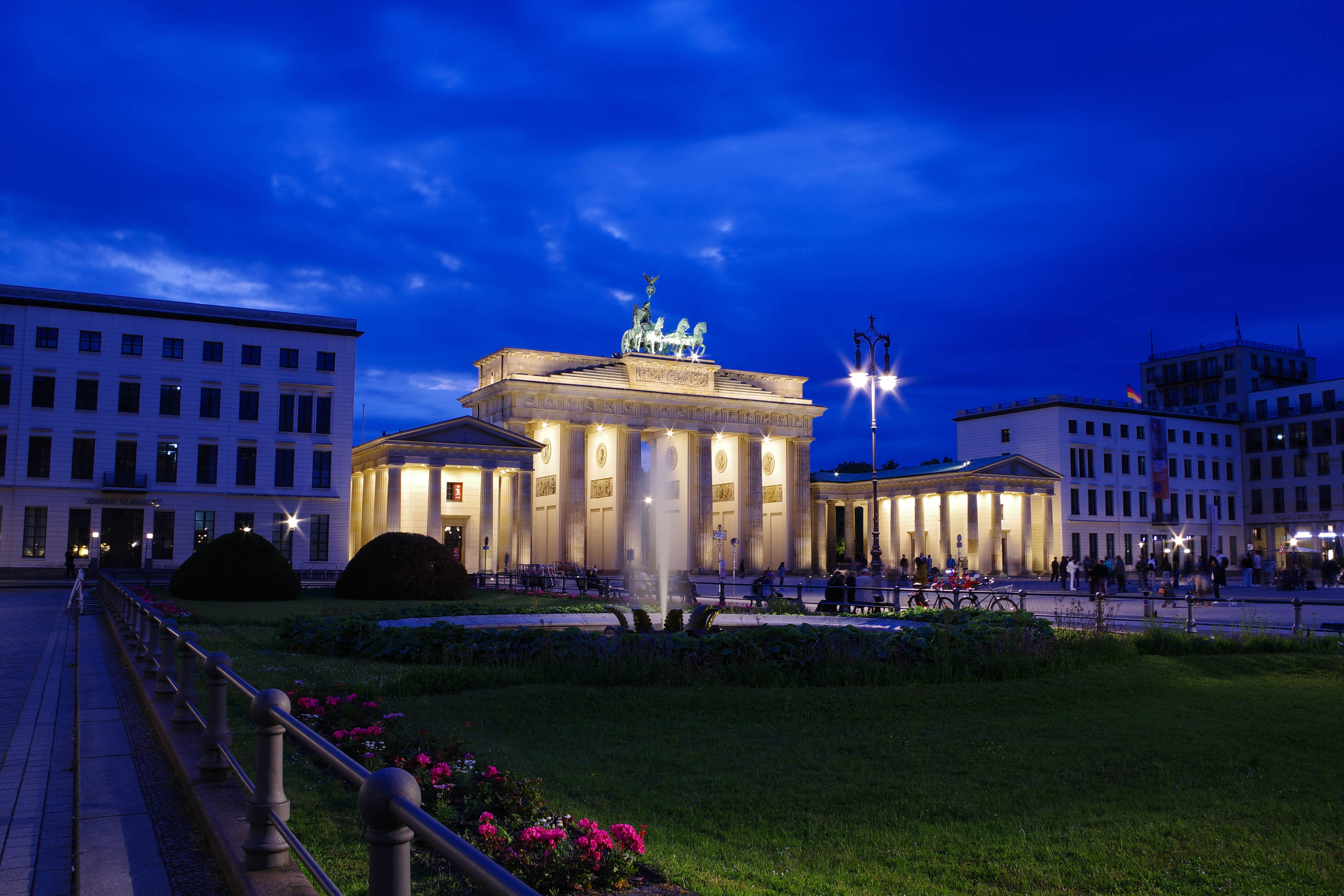 A red and blue stock car racing at high speeds at the Paragon Speedway in Bloomington, Indiana. The racecar is racing at high speeds in the night time, therefore, it is illuminated by the bright lights