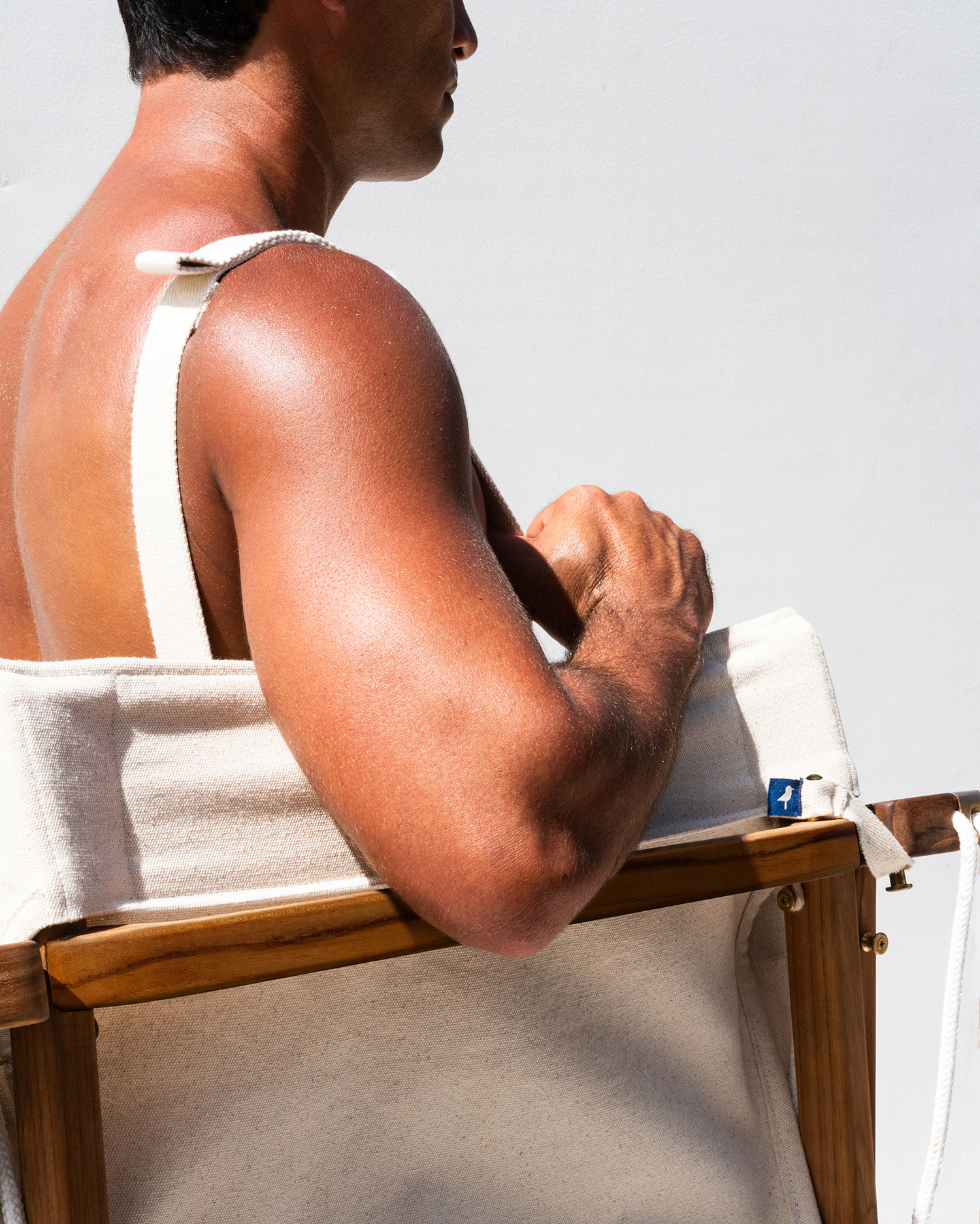 Man carrying Shorebird Chair using shoulder strap.