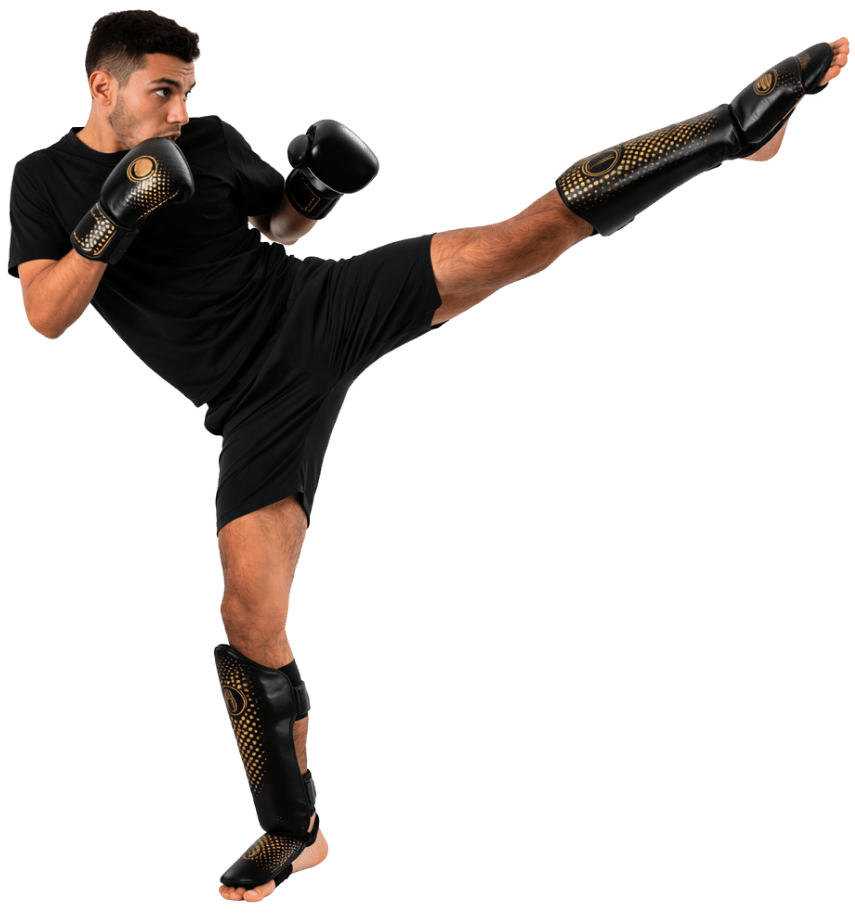 Martial artist wearing black gloves and shin guards performing a high side kick.