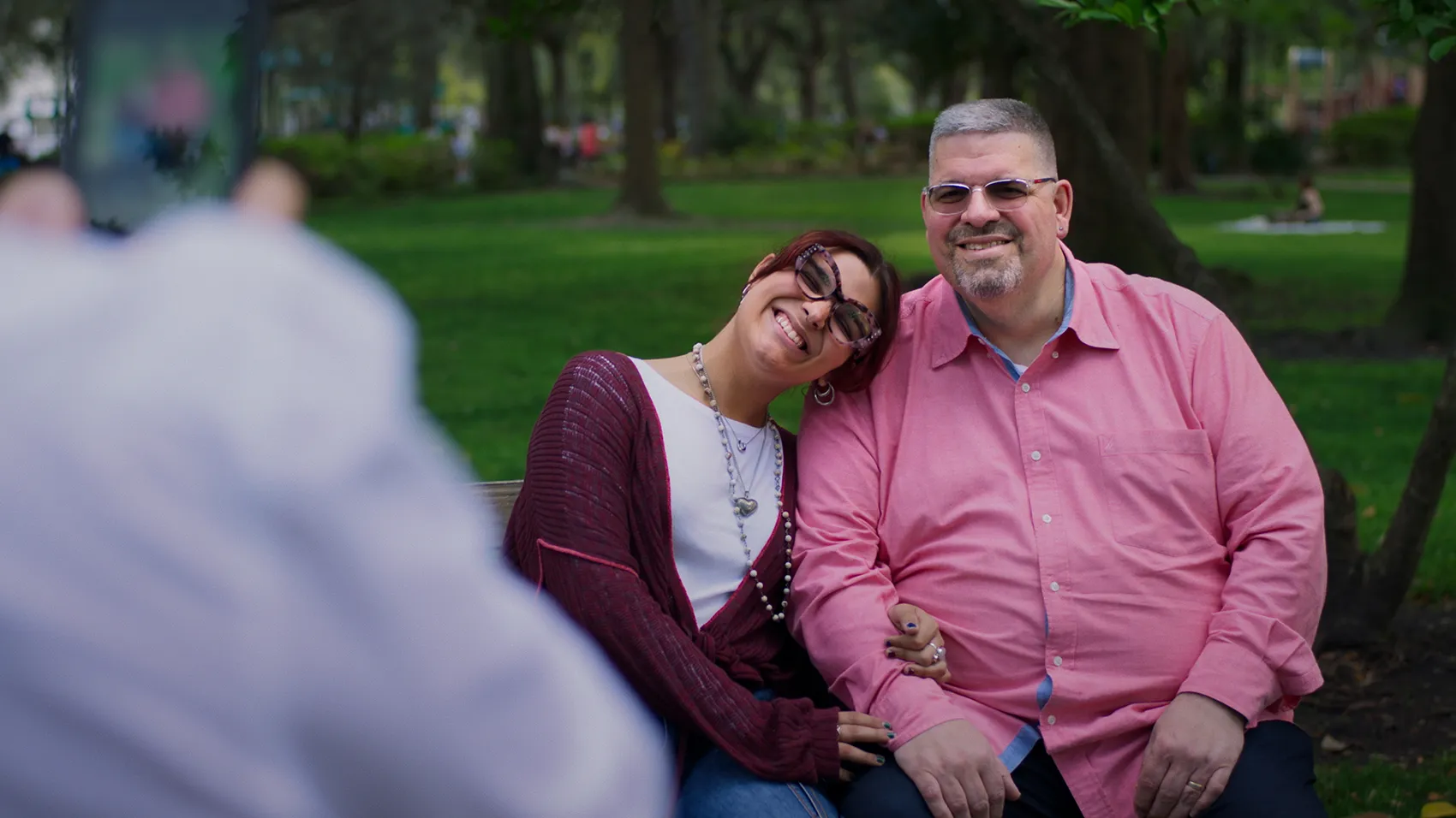 Nadya sitting outside with her dad, smiling