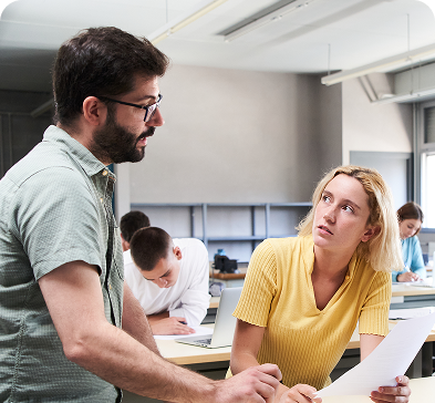 An expert guiding a student in a classroom environment