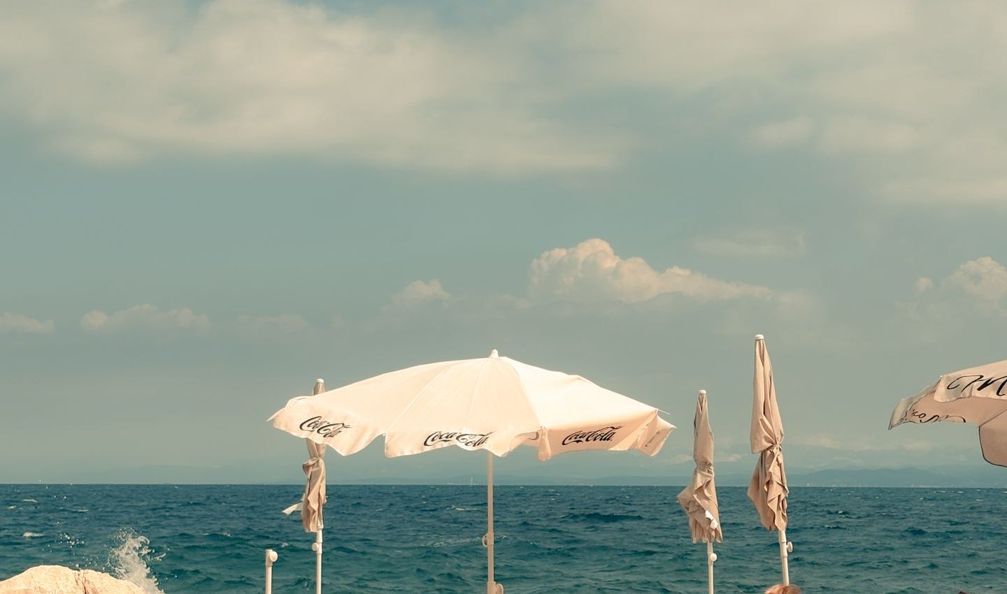 Beach loungers and umbrellas by a calm sea at sunset