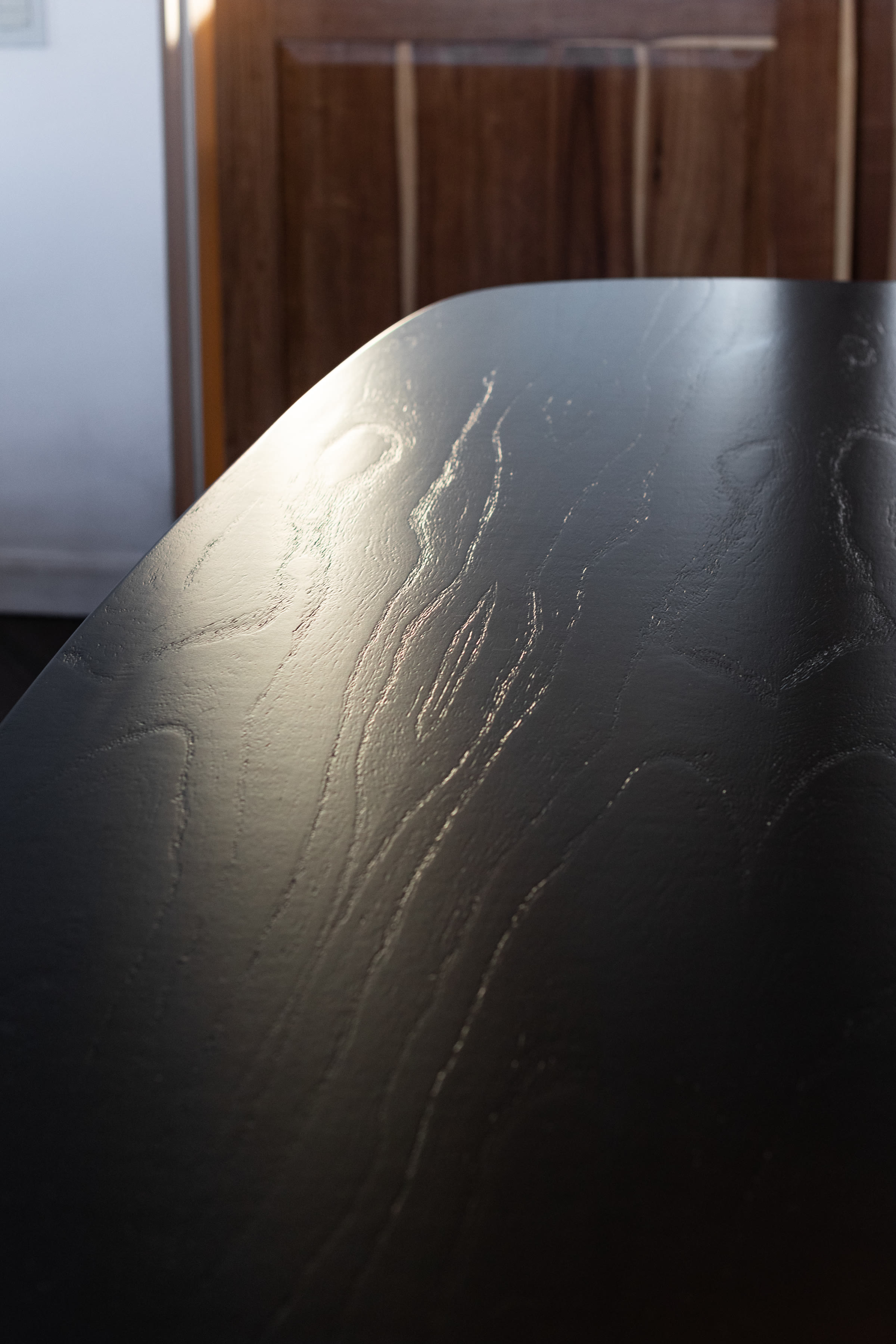 Open-pore wood grain on the dark dining table surface