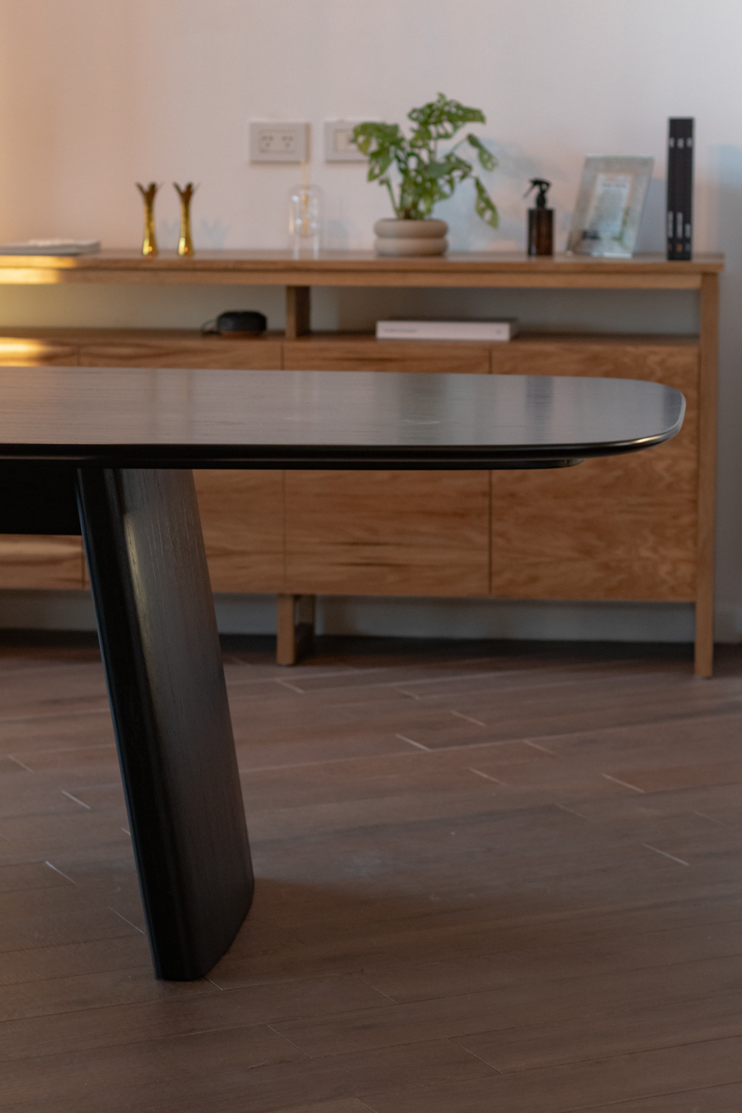 Detail of angled dining table leg and open-pore wood grain