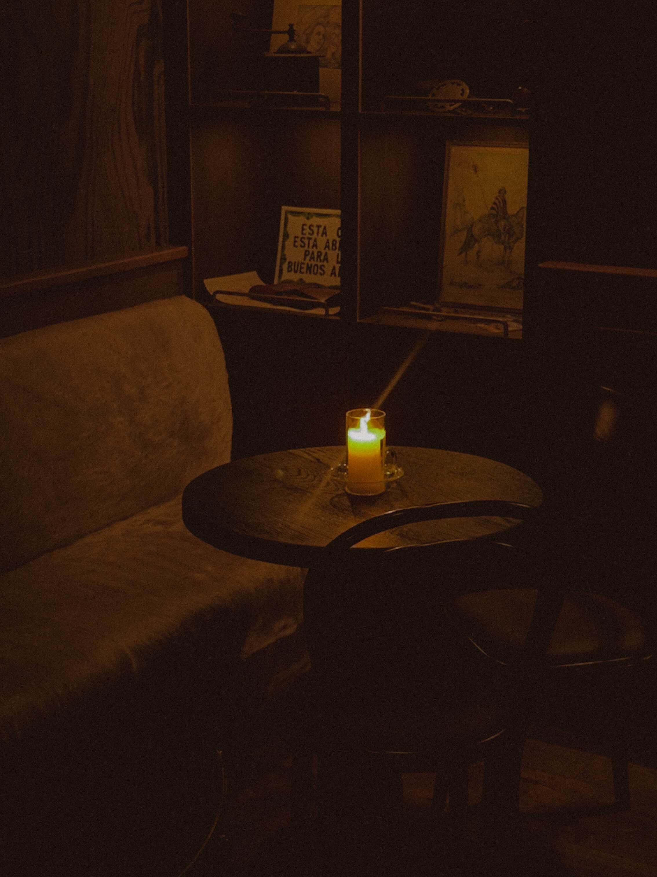 Candlelit corner with glass hurricane and Patagonia-inspired shelving at SUR Milano