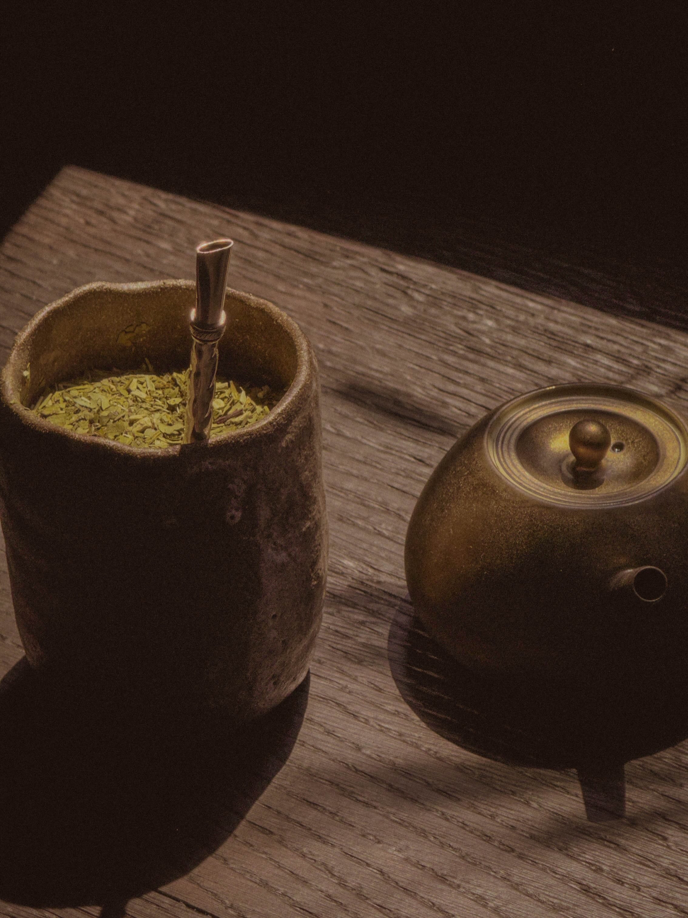 Yerba mate ceramic vessel with bombilla and bronze teapot at SUR Milano