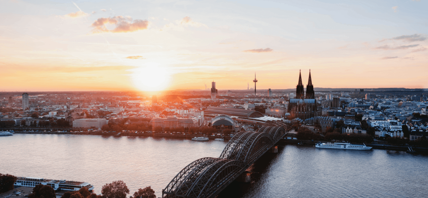 Sonnenuntergang über Köln mit Blick auf den Kölner Dom, die Hohenzollernbrücke und den Rhein – idealer Studienort für ein duales Studium in Köln.