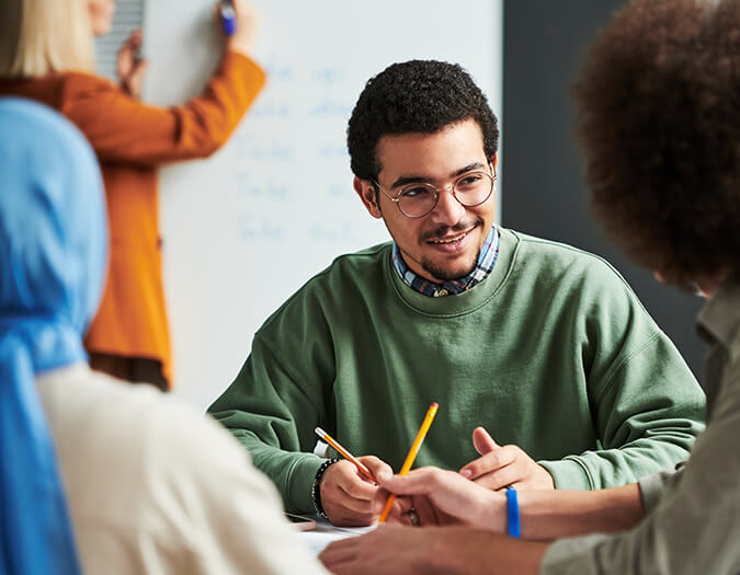 Marketing Data Analyst in einer Gruppenarbeit: Ein Student erklärt Daten und Strategien im Team. Darstellung der Karrierechancen nach dem  Data Analytics an der  im Bereich Marketing Data Analytics.