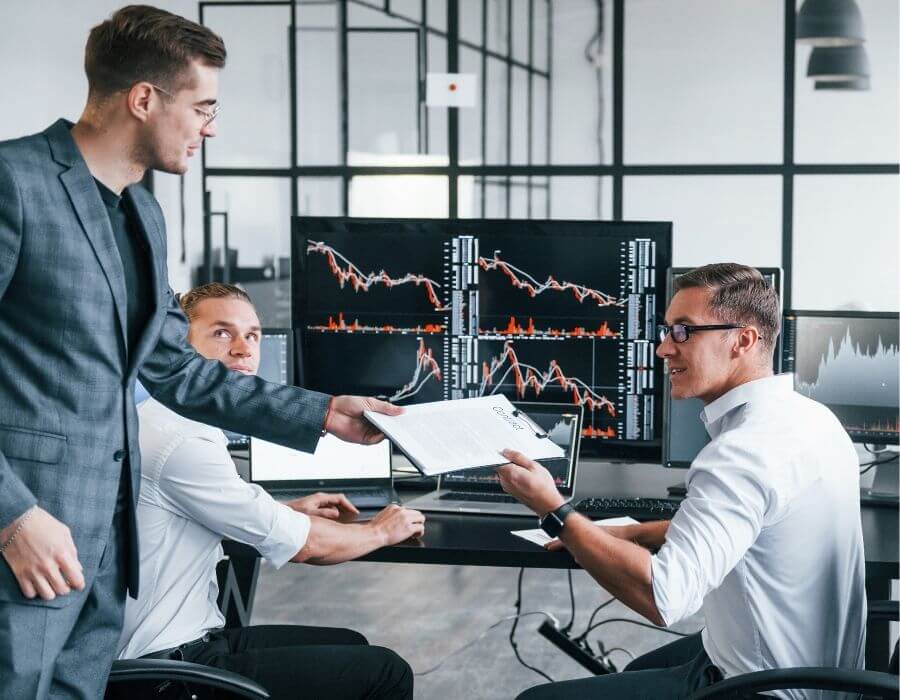 Studierende im dualen Data Analytics Studium an der CBS analysieren Daten und Finanzdiagramme auf Monitoren zur Vorbereitung datenbasierter Managemententscheidungen.