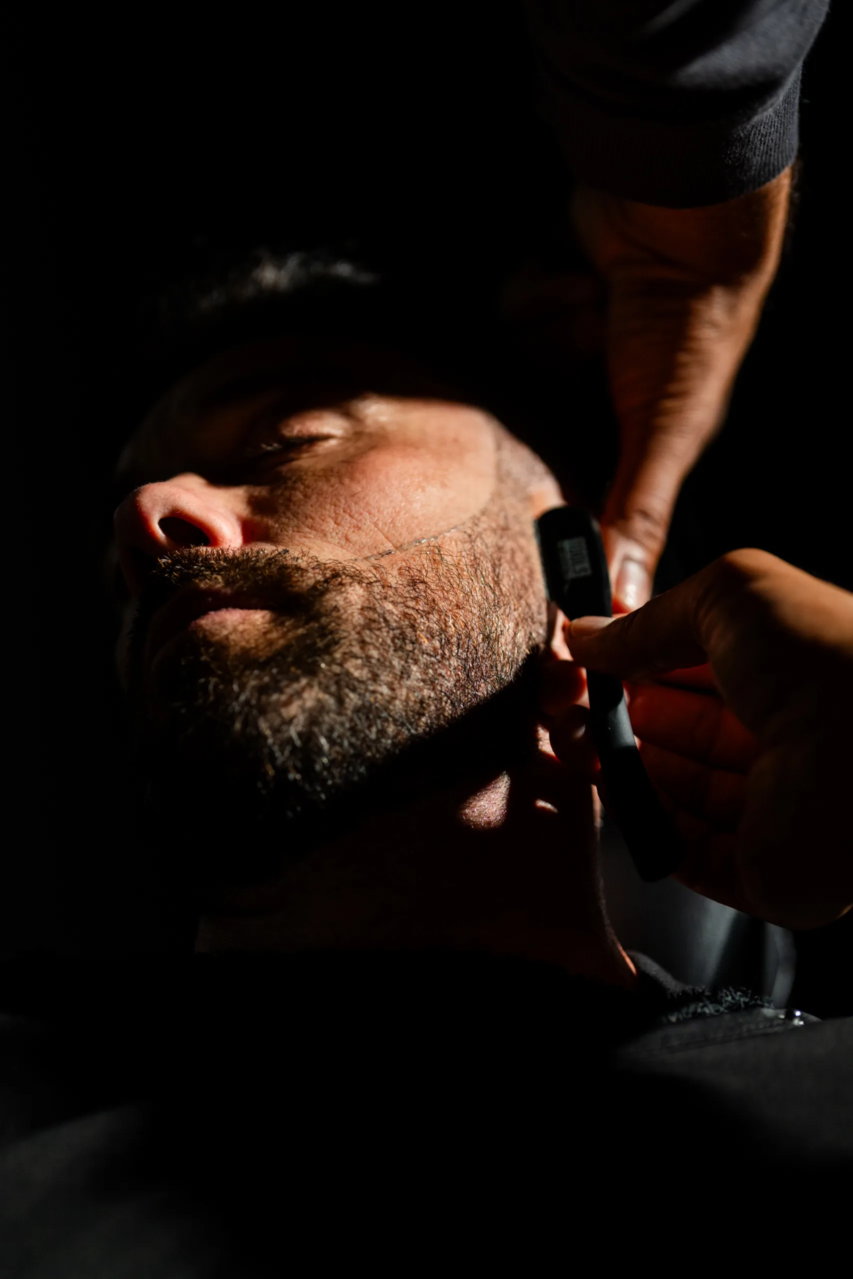A barber shaping a beard