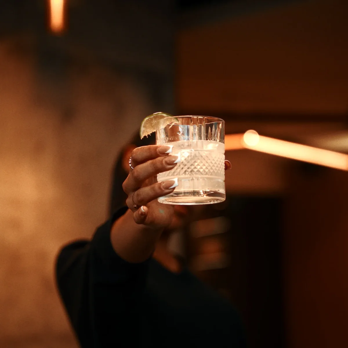 A crystal glass raised in warm light