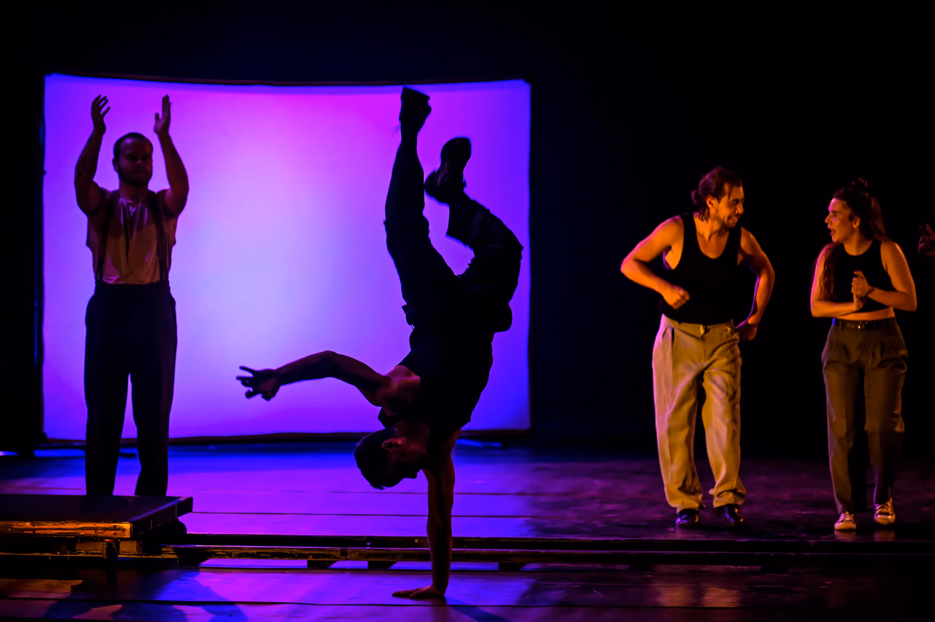 Danzatori dinamici sul palco al Festival di Spoleto con illuminazione viola