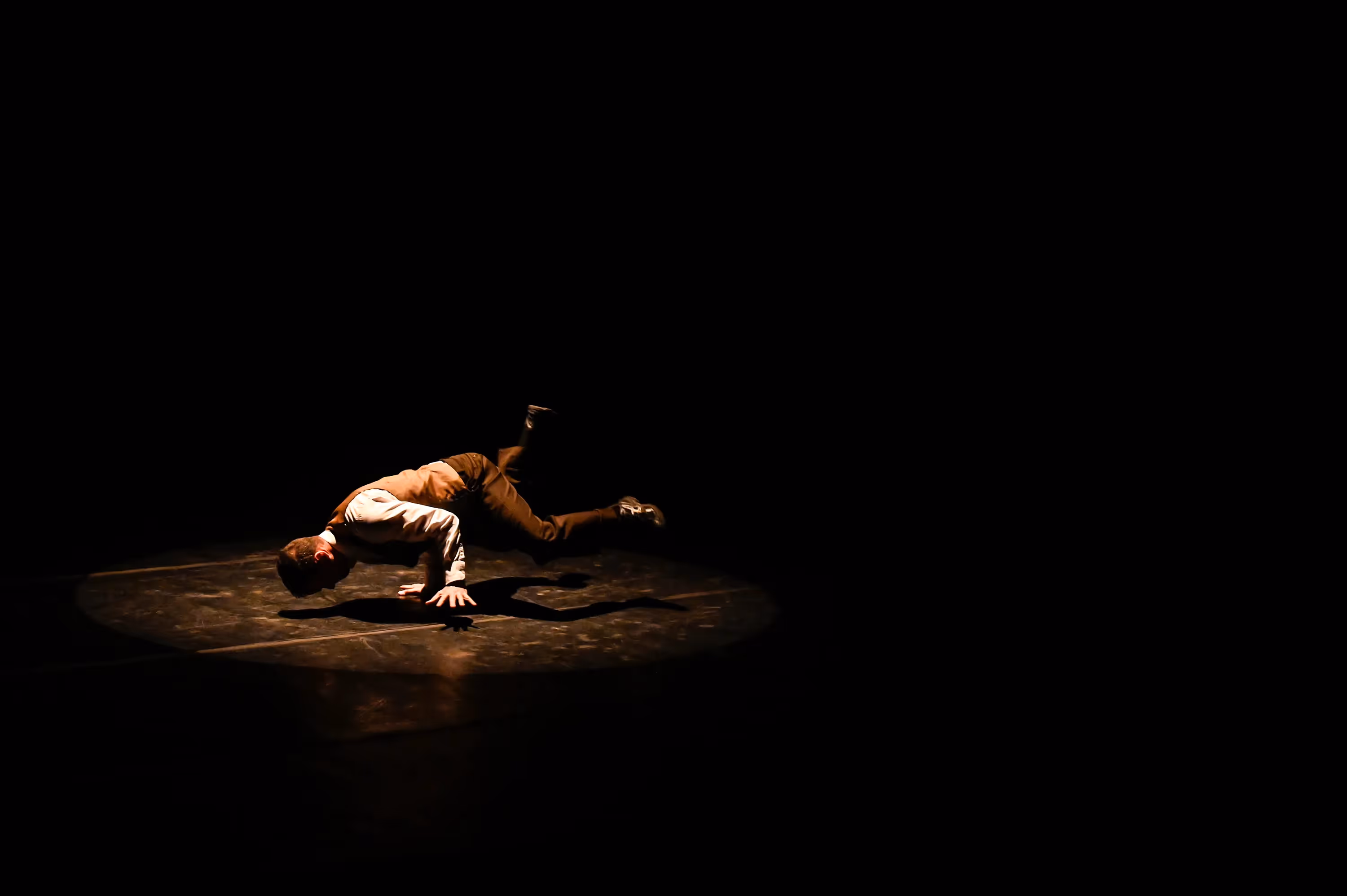 Performer drammatico sul palco al Festival di Spoleto, illuminato dall'oscurità