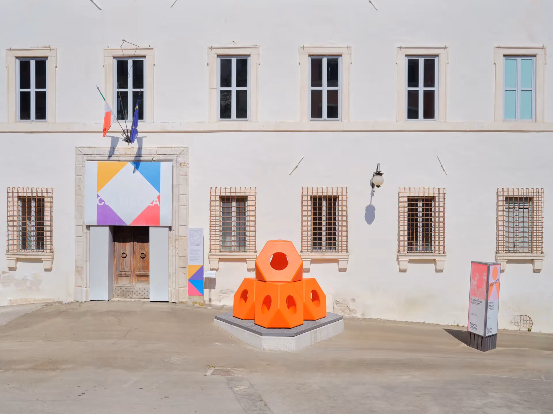 Installazione artistica arancione al Festival di Spoleto davanti a edificio storico
