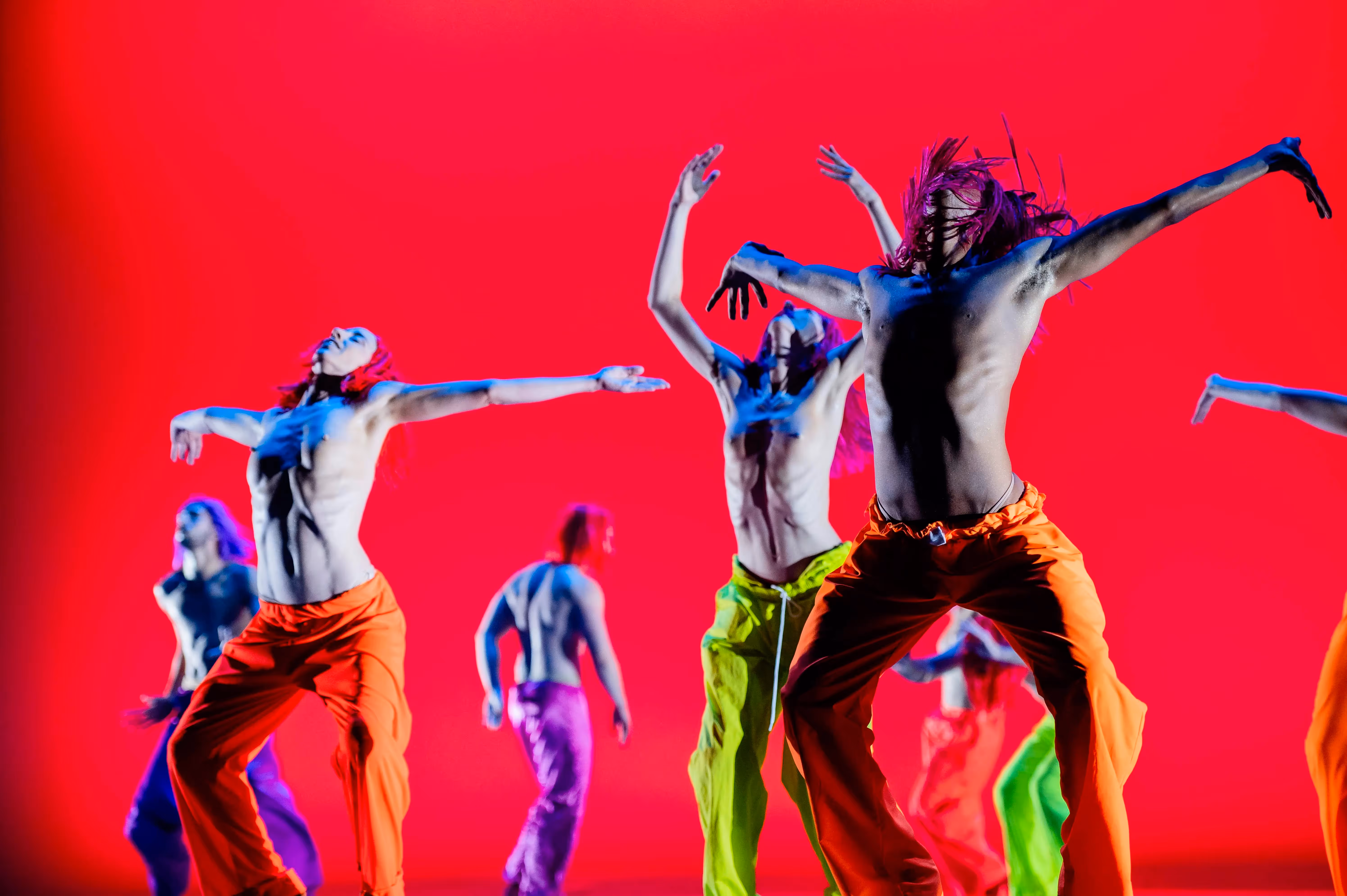 Danzatori energici nel Festival di Spoleto, movimenti dinamici su sfondo rosso