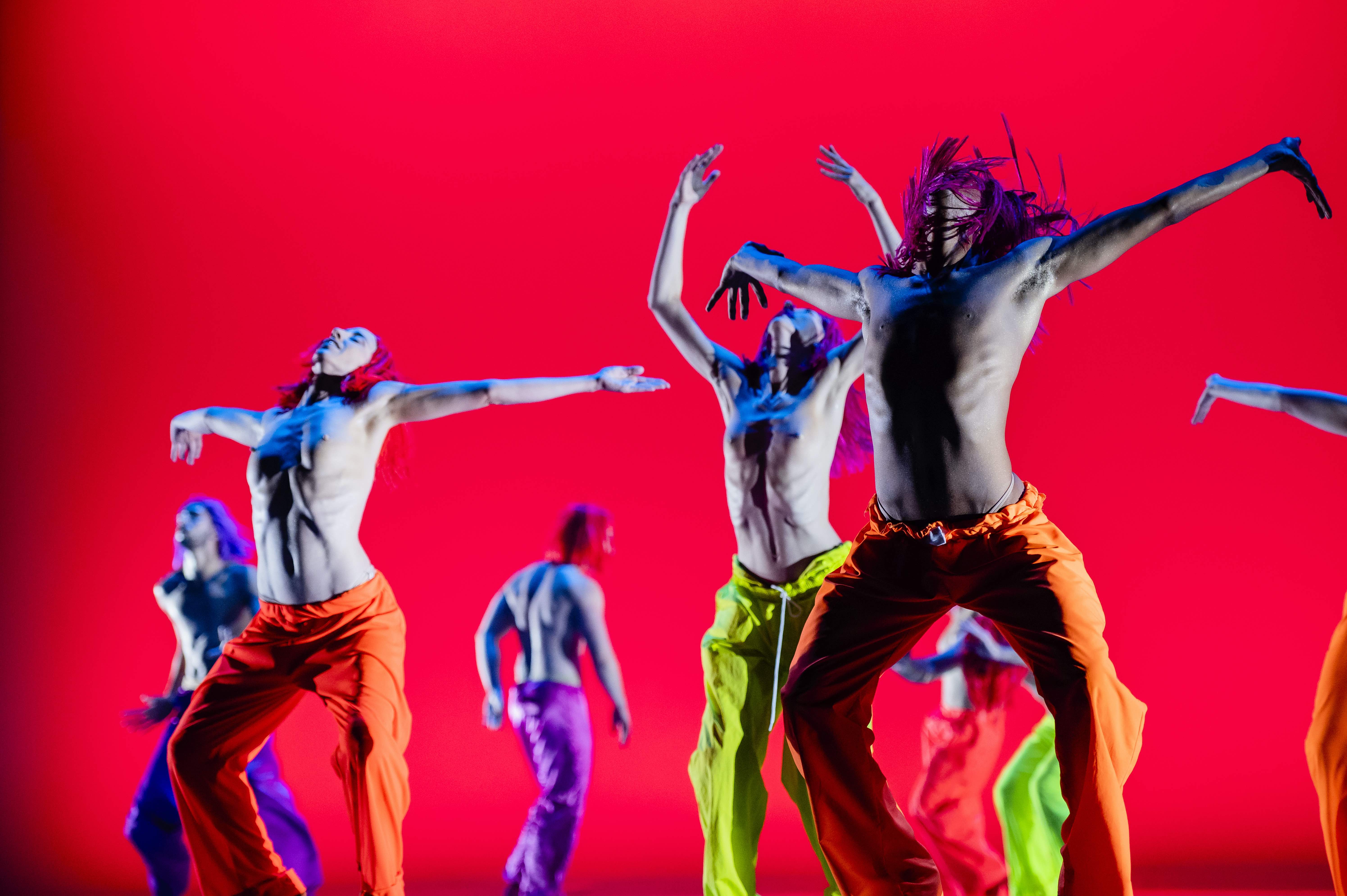 Danzatori energici nel Festival di Spoleto, movimenti dinamici su sfondo rosso