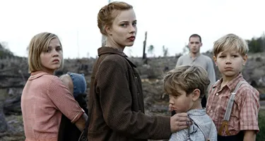 Festival di Spoleto poster featuring somber post-war family in desolate landscape