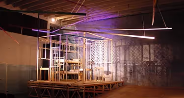 Artistic stage design at Festival di Spoleto with wooden scaffold and purple lighting