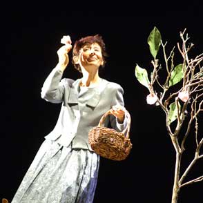Festival di Spoleto performer in vintage dress holding basket near bare tree
