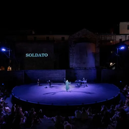 Spettacolo teatrale 'Soldato' al Festival di Spoleto, palcoscenico blu illuminato